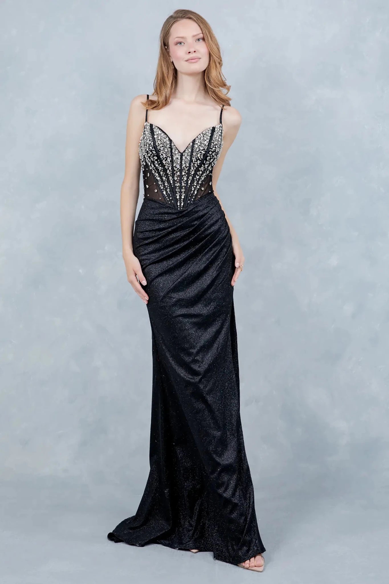 A full-length view of a woman wearing black glitter formal dress with a lace-up corset.
