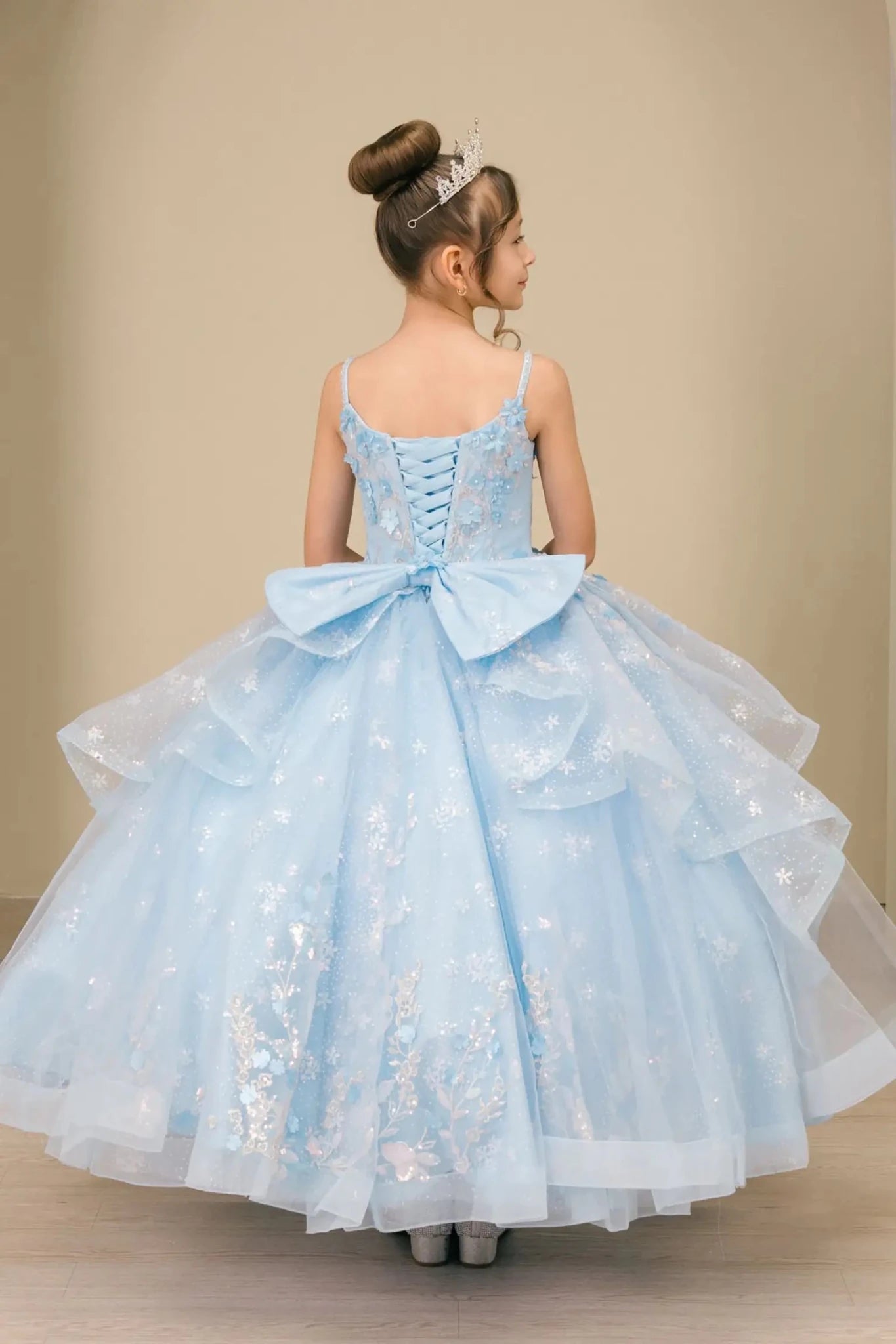 Back view of mini quinceañera mini quince dress with lace-up corset bodice, oversized bow accent, and layered skirt.