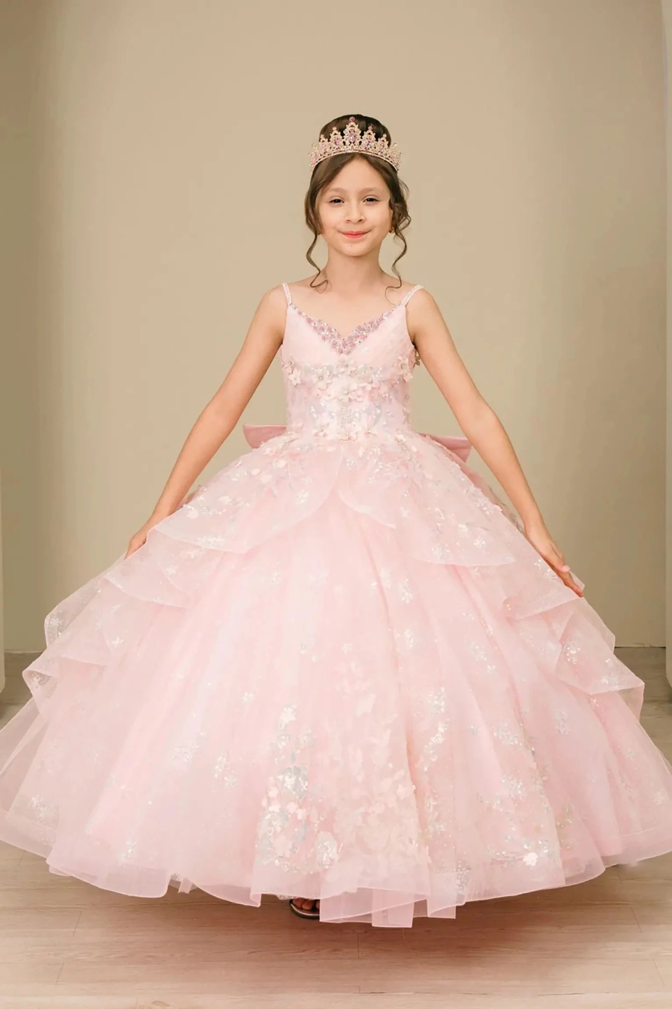 Young girl standing front-facing in mini quinceañera ball gown with V-neck corset bodice, sequin floral embroidery, and layered skirt