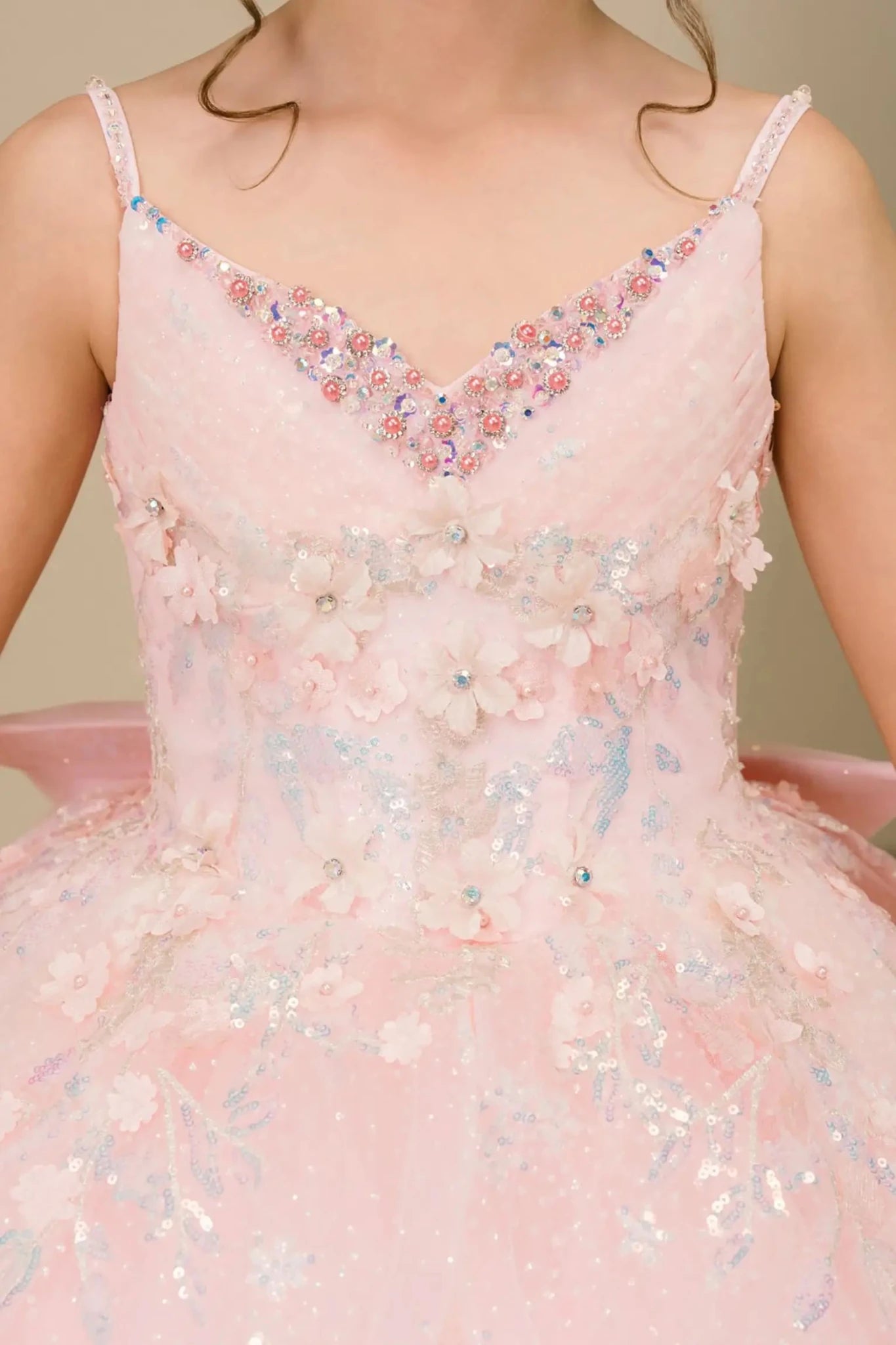 Close-up front-facing view of mini quinceañera ball gown with V-neck corset bodice and sparkling sequin floral embroidery