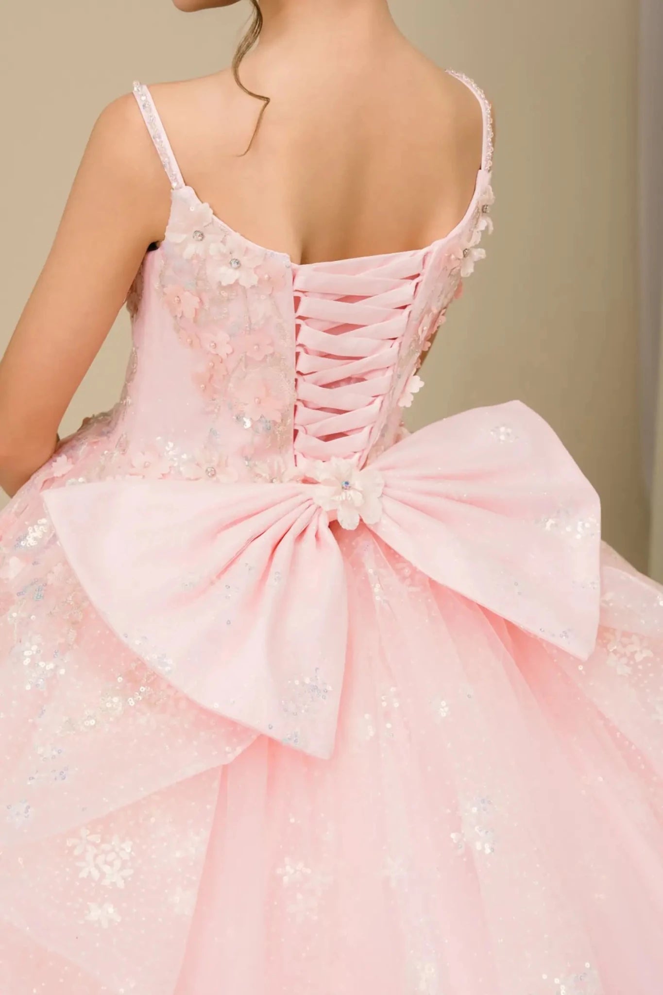 Close-up of mini quinceañera ball gown fabric with sequin floral embroidery and shimmering tulle layers