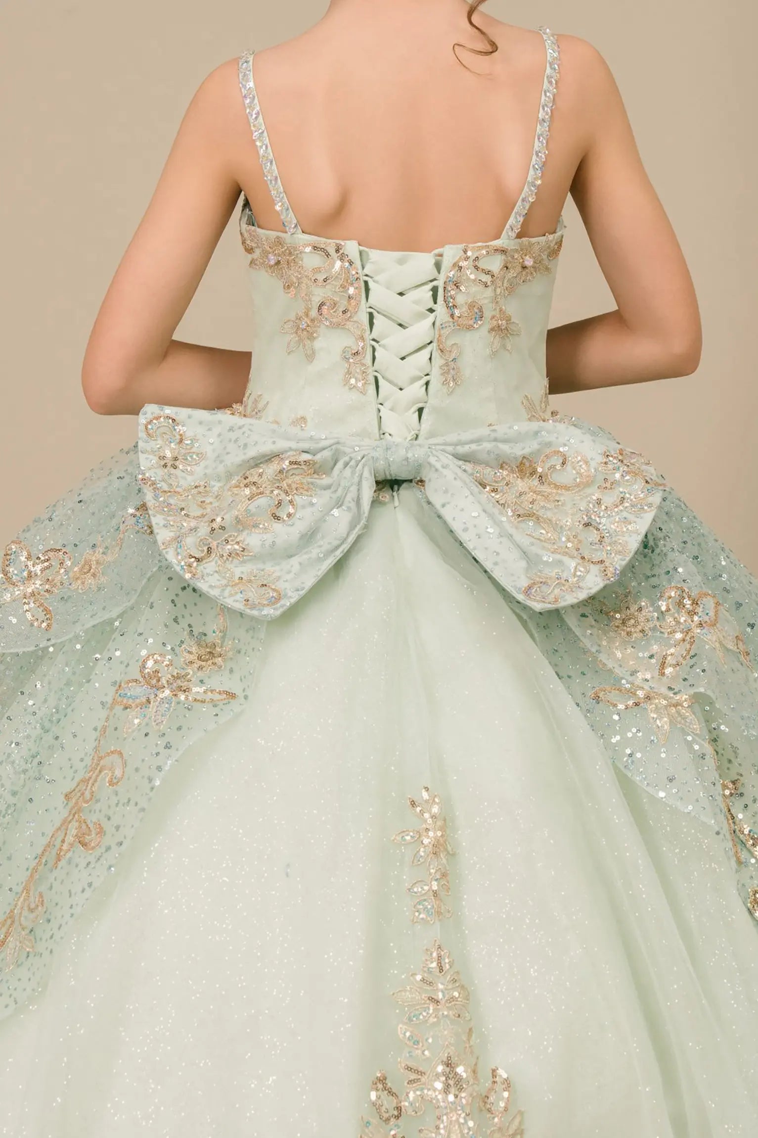 Bodice back close-up of a sage kids quinceañera dress with gold embroidery, sequins, and lace-up corset design.