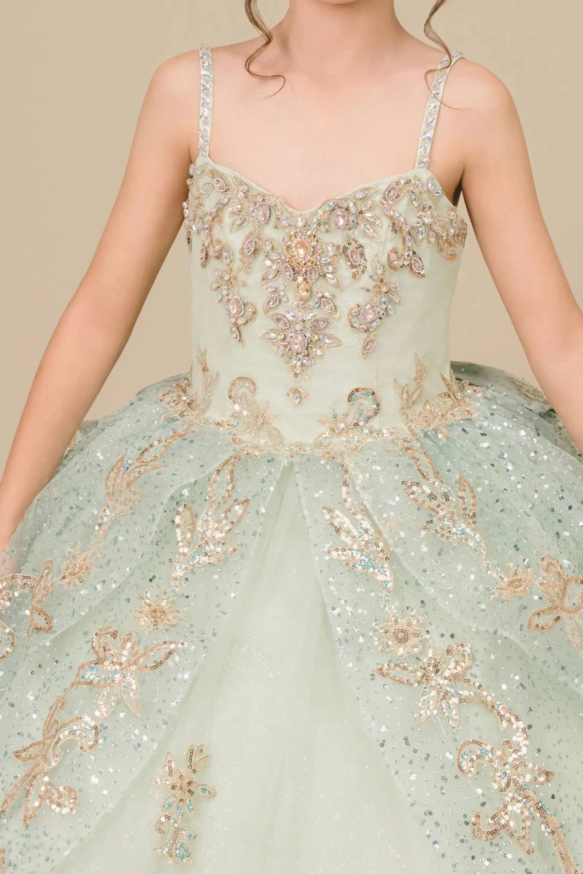 Close-up view reveals bodice close-up of a sage kids quinceañera mini quince dress showing gold embroidery, sequins.