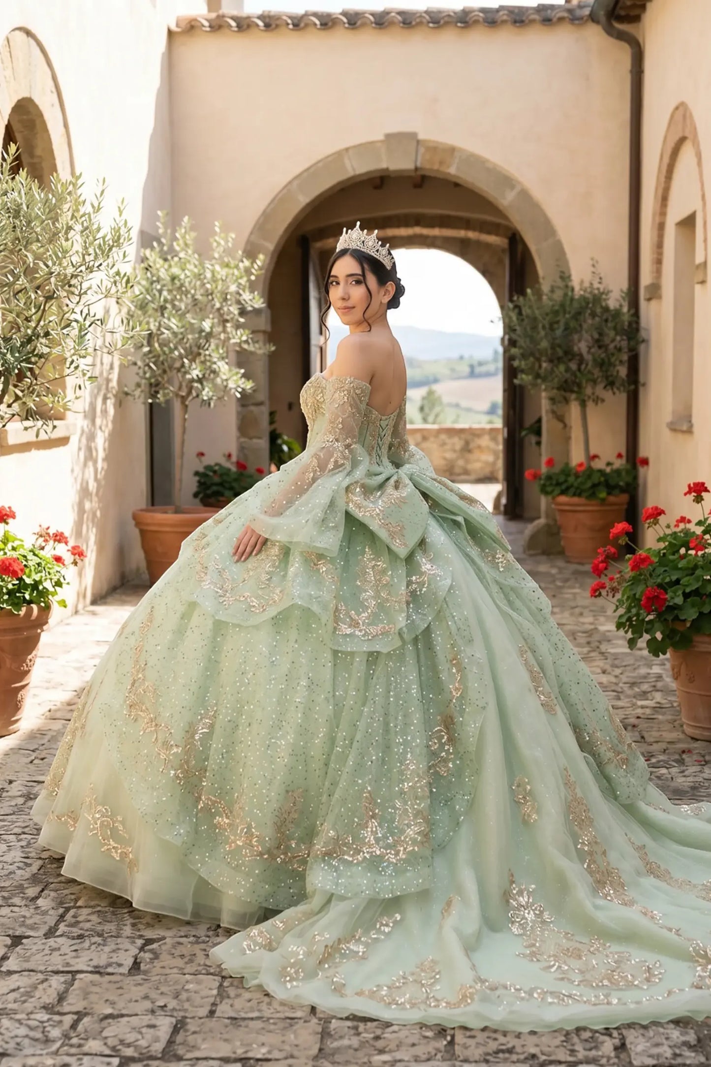 Side close-up view of a woman wearing sage quinceañera dress highlighting layered glitter tulle, embroidered bodice, and flowing ball gown silhouette.