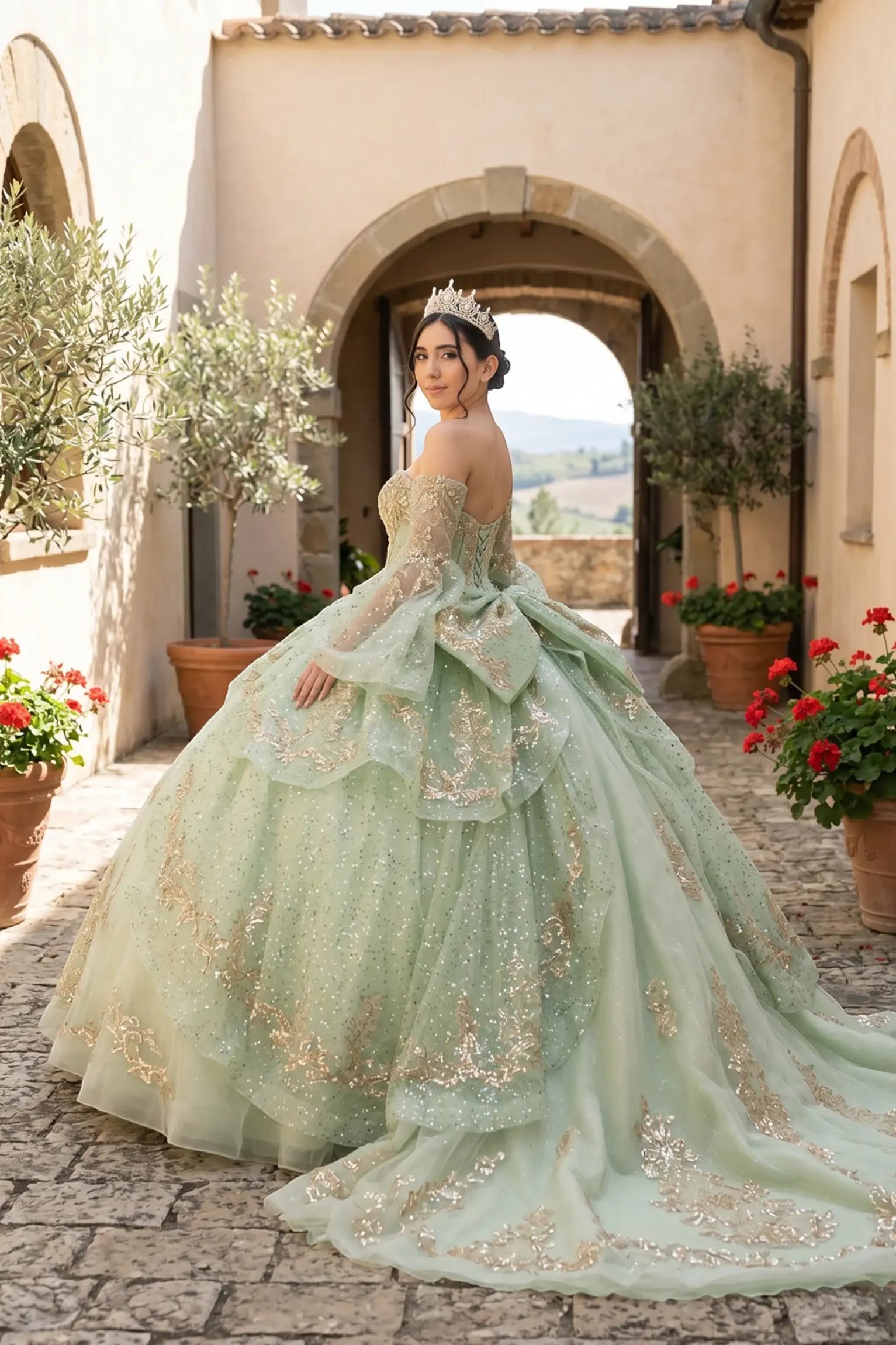 Side close-up view of a woman wearing sage quinceañera dress highlighting layered glitter tulle, embroidered bodice, and flowing ball gown silhouette.