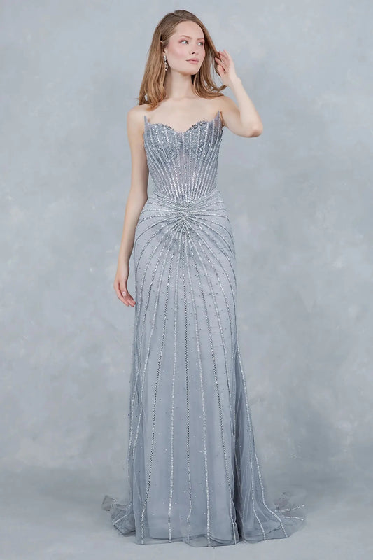 A full-length view of a woman wearing silver formal prom dress with a lace-up corset.