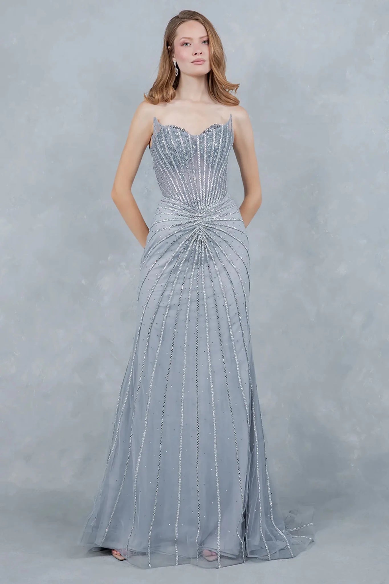 Full front view of a women wearing silver crystal mermaid prom dress with radiant embellishments.