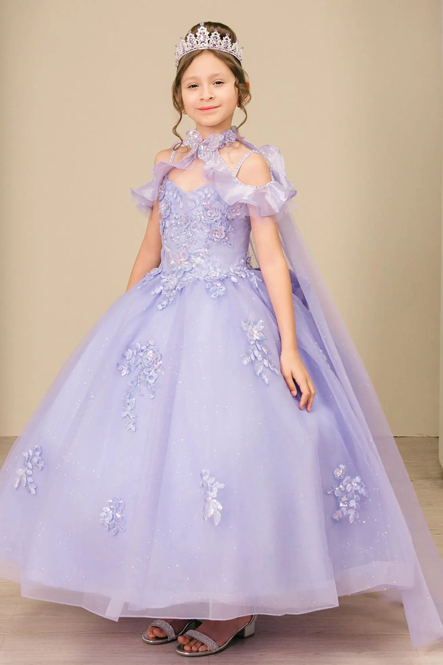 Full front view of a kid wearing lilac mini quinceañera dress with shimmering tulle skirt, off-shoulder ruffled sleeves, and glitter-embellished bodice.