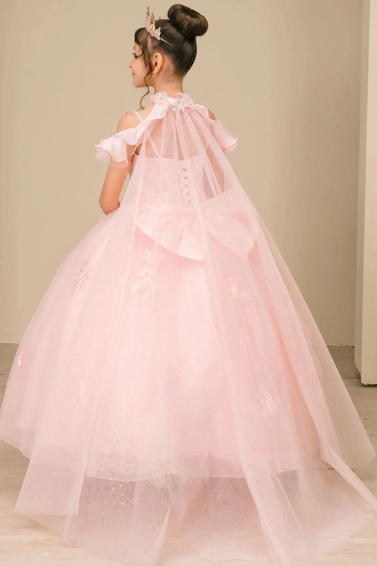 Back detail shows pink mini quinceañera mini quince dress with voluminous tulle skirt, lace-up corset closure.
