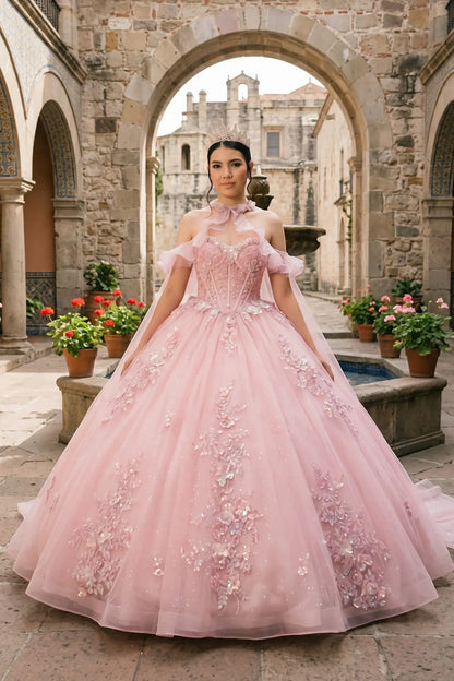 Full front view of a woman wearing pink quinceañera dress with glitter tulle skirt, off-shoulder ruffled sleeves, and beadwork corset bodice.