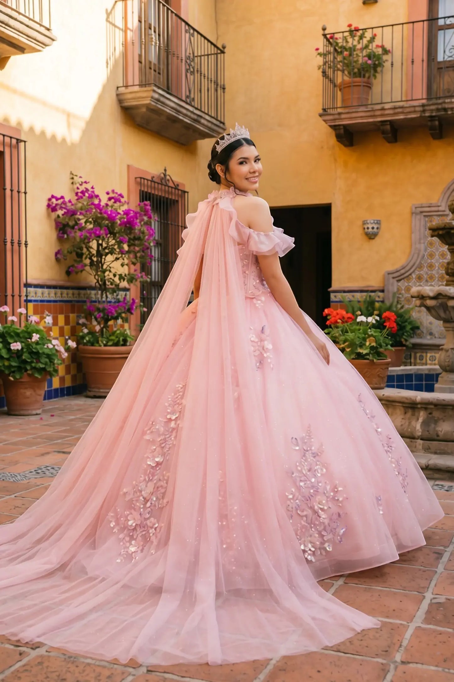 Full back view of a woman wearing pink quinceañera dress showing floral appliques, butterfly collar detail, and sparkling beadwork accents.