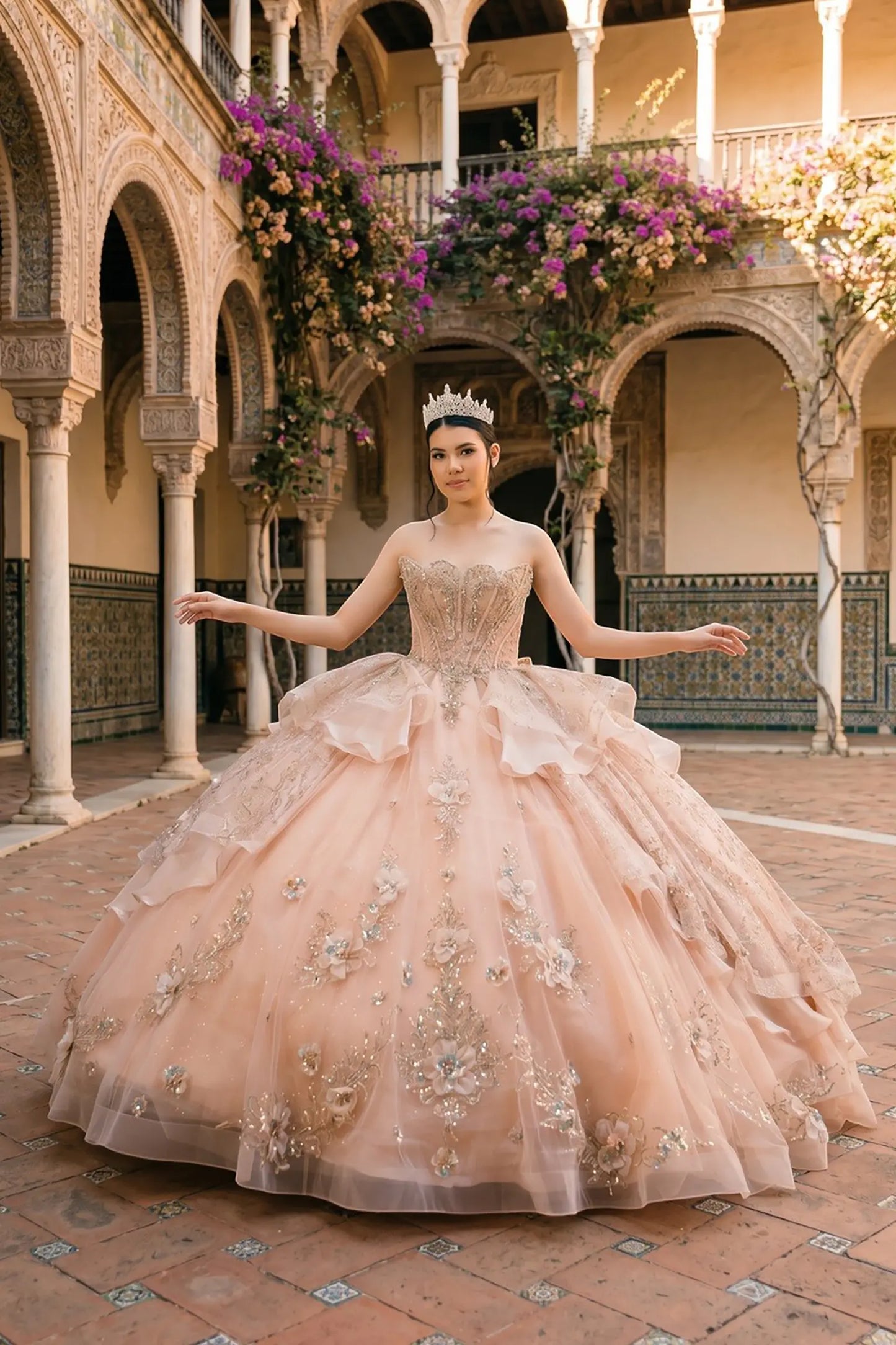 Full front view of a woman wearing rose gold quinceañera dress with glitter tulle skirt, beaded corset bodice, and floral appliques.