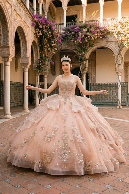 Full front view of a woman wearing rose gold quinceañera dress with glitter tulle skirt, beaded corset bodice, and floral appliques.