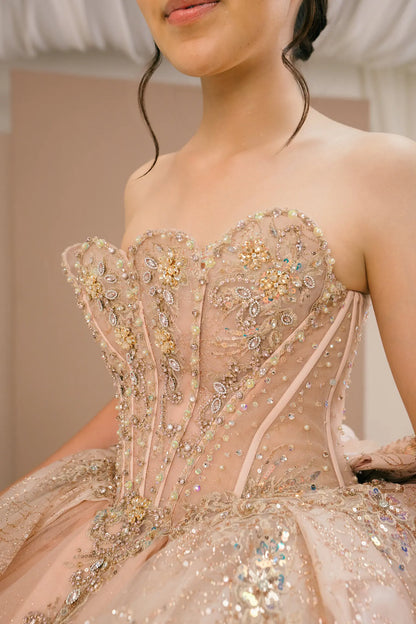 Side close-up view of a woman wearing rose gold quinceañera dress highlighting beaded corset bodice, glitter tulle layers, and floral appliques.