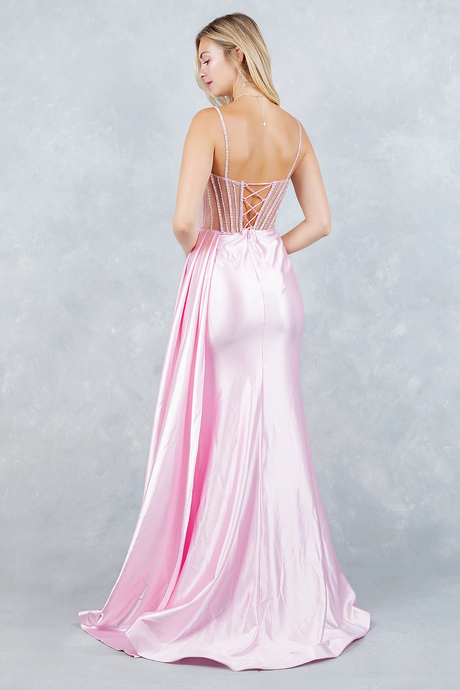 Pink evening gown styled with delicate spaghetti straps and lace-up back