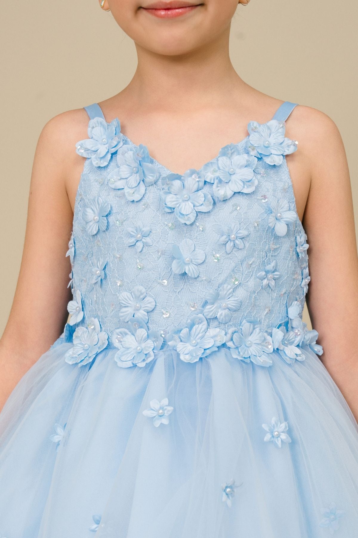 Close-up front-facing view of sky blue high-low tulle flower girl dress with 3D floral appliqué bodice and elegant neckline.