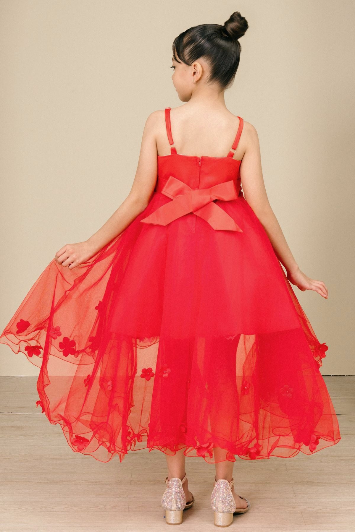 Back view of red high-low tulle flower girl dress with lace-up bodice, 3D floral appliqué accents, and dramatic high-low skirt.
