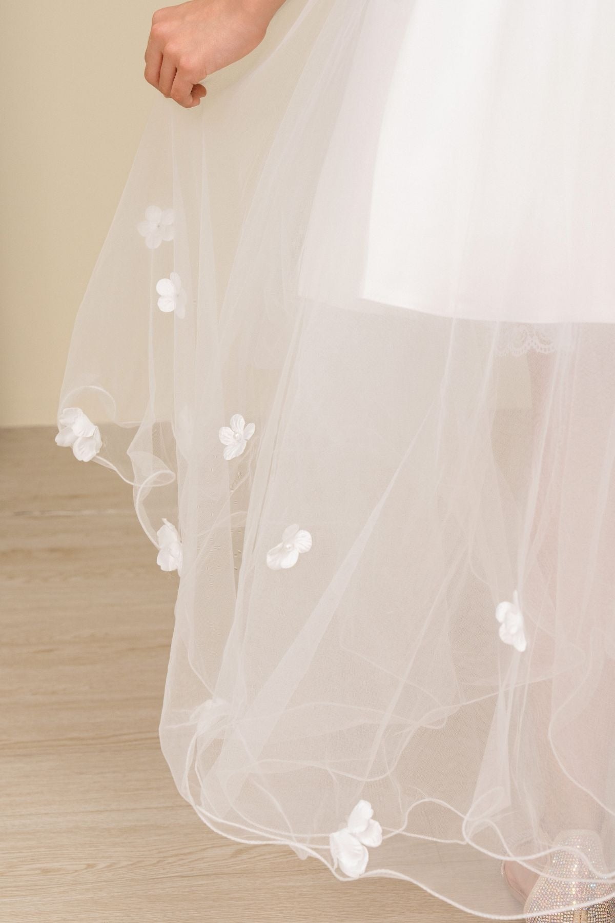 Close-up of sky blue high-low tulle flower girl dress fabric with 3D floral appliqué embroidery and layered tulle texture.