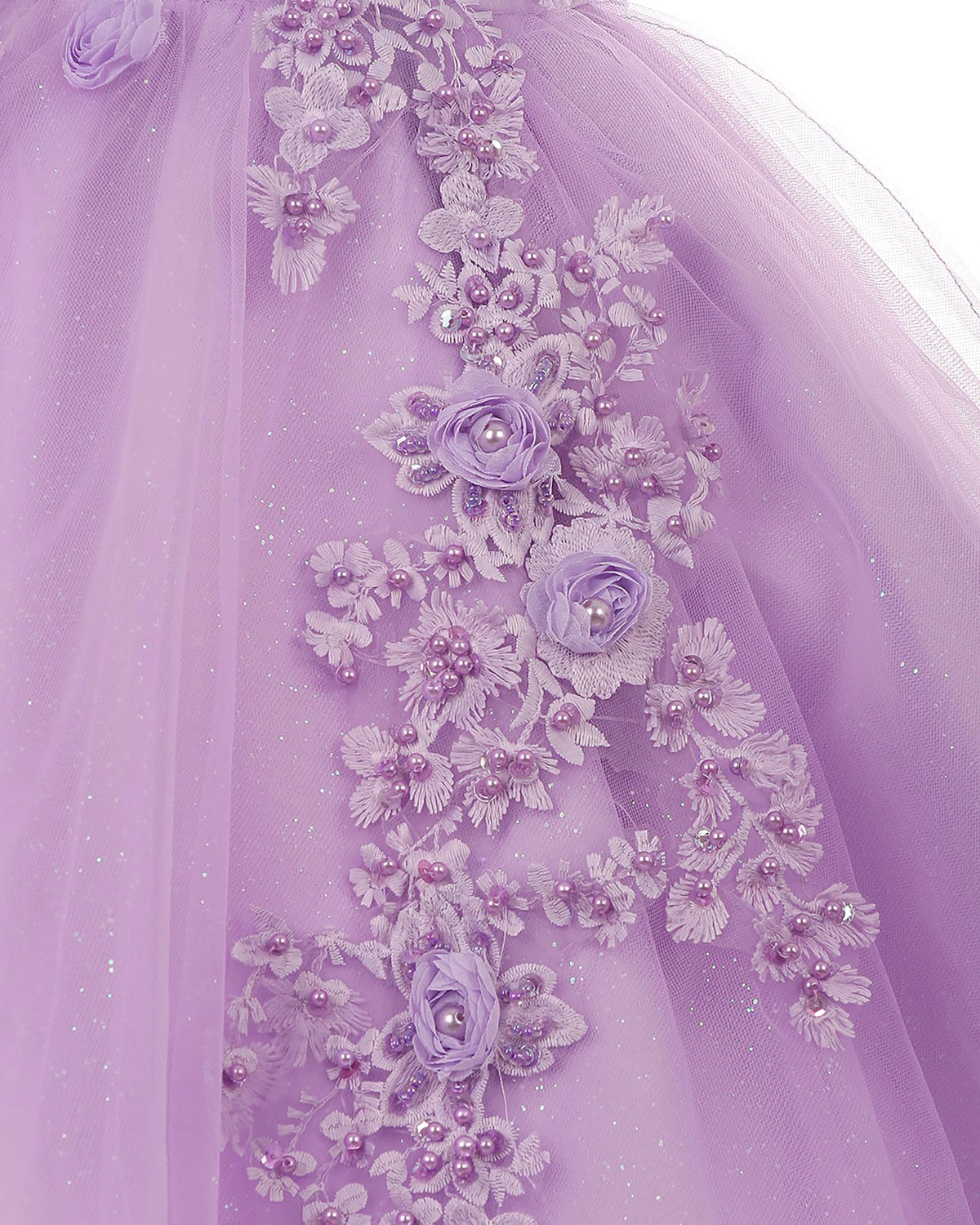 Close-up of a lilac flower girl dress with floral embroidery and bead details.
