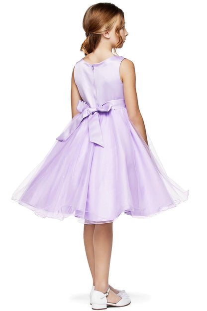 Young girl wearing a lilac dress with a bow on a white background