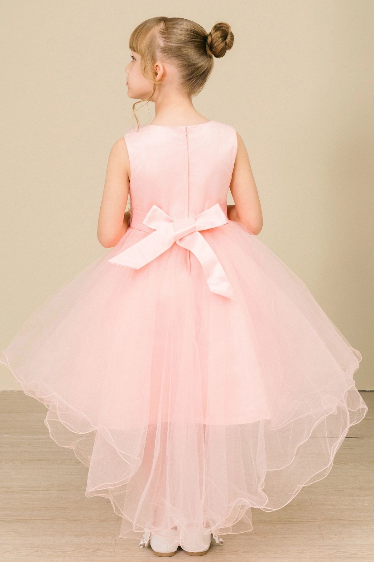 A Blush flower girl dress showing back satin bow above a high-low tulle skirt.