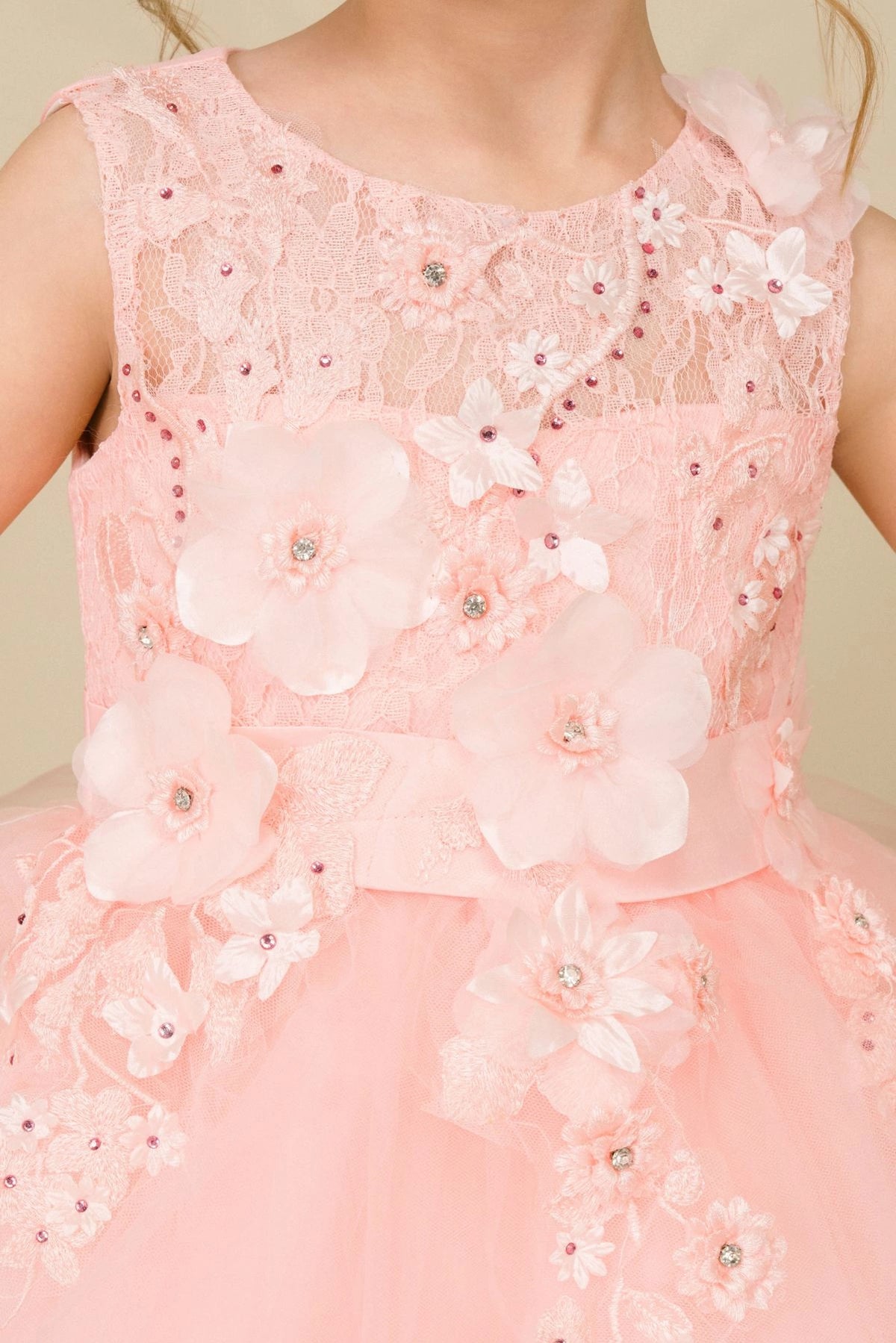 Visible on this Blush flower girl dress: three-dimensional flowers and pearl-like accents.