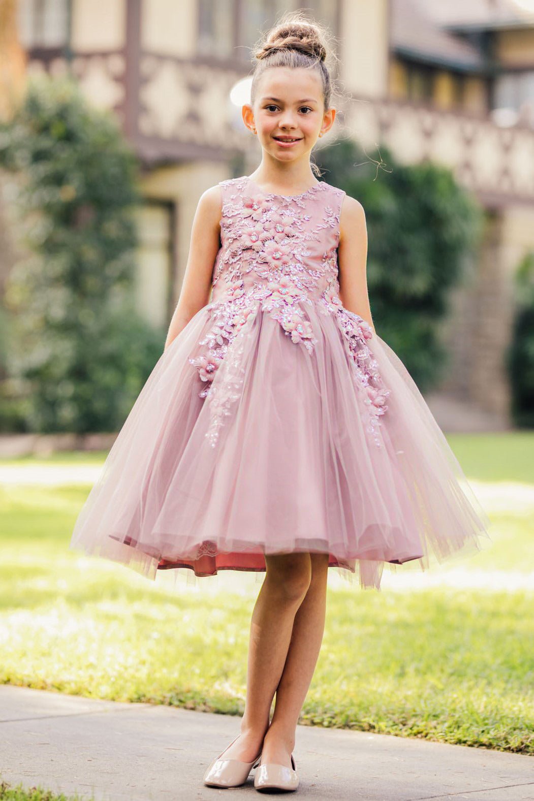 Front view of mauve sleeveless flower girl dress with 3D floral appliqué bodice and wired layered tulle skirt.