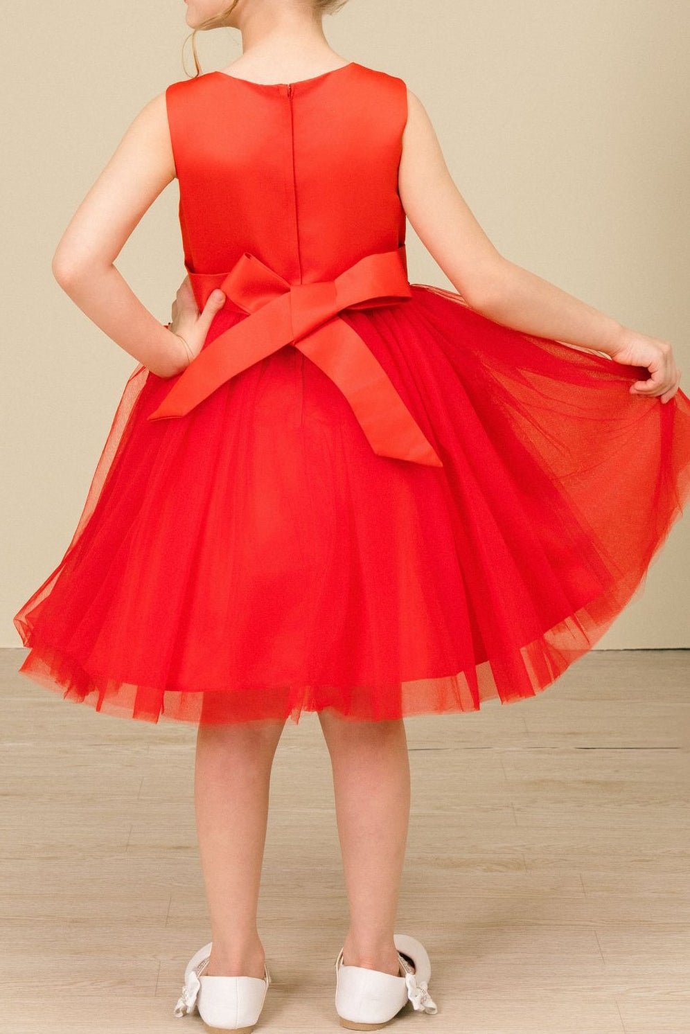 Back view of red sleeveless flower girl dress with lace-up bodice, 3D floral appliqué accents, and wired tulle skirt.