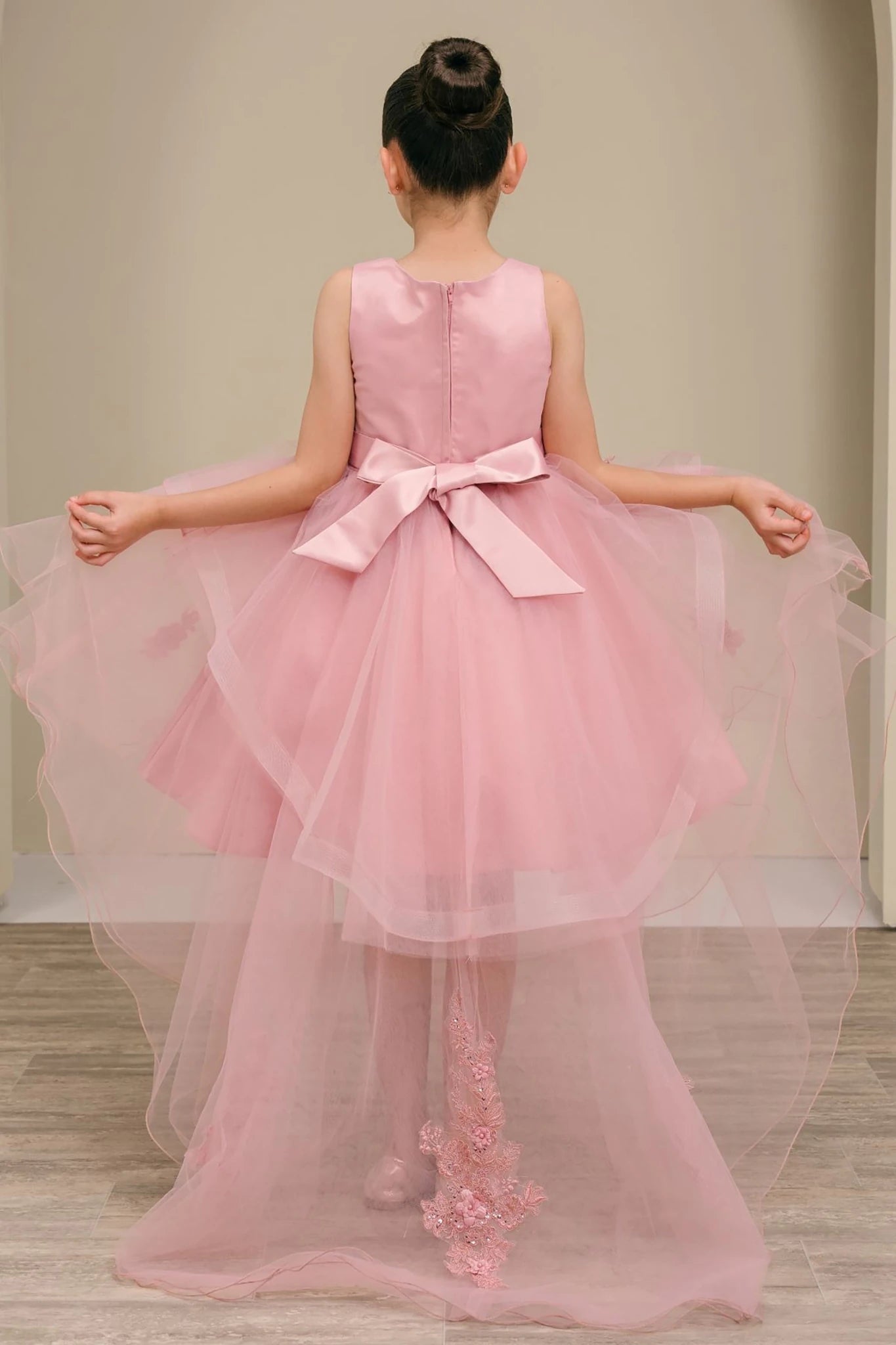 Dusty rose high low flower girl dress with a bow and floral details.