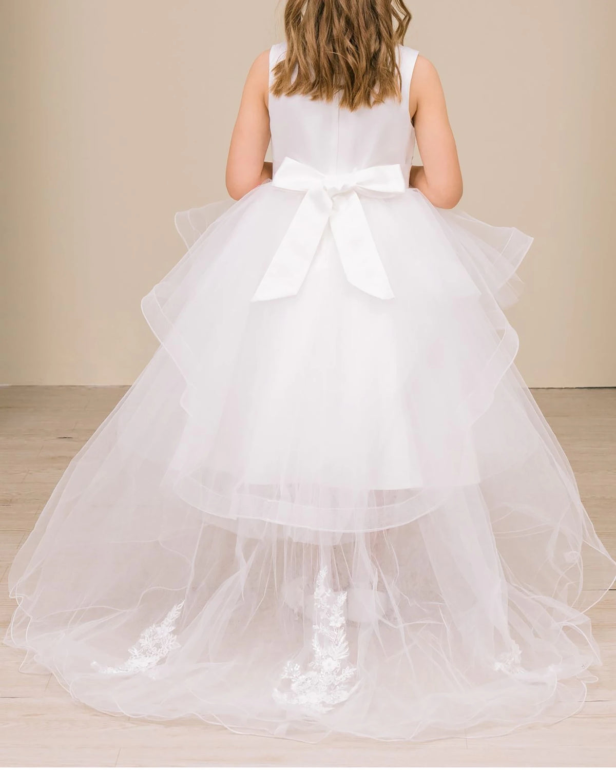 White flower girl dress with a large bow.