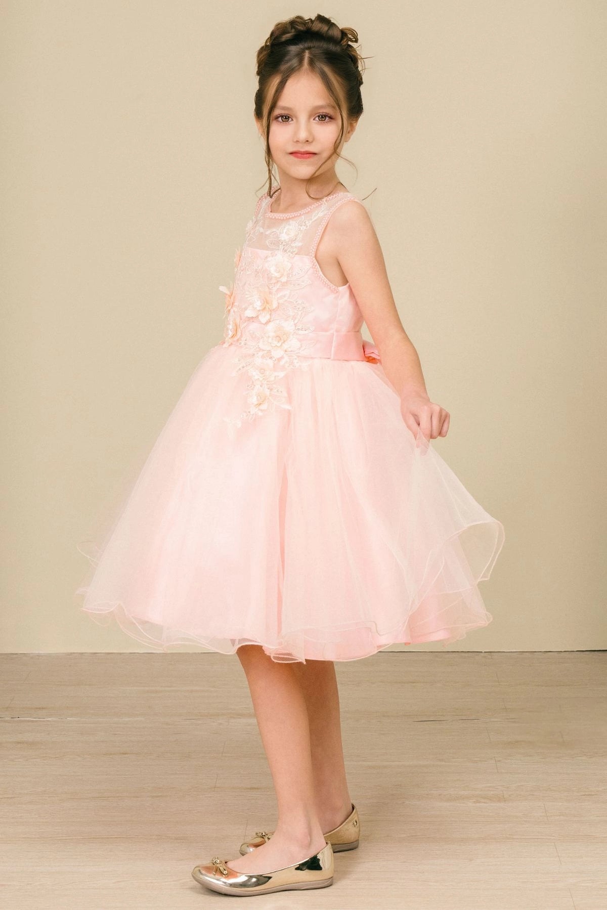 Featuring layered tulle hem beneath the fitted bodice on the Peach flower girl dress.