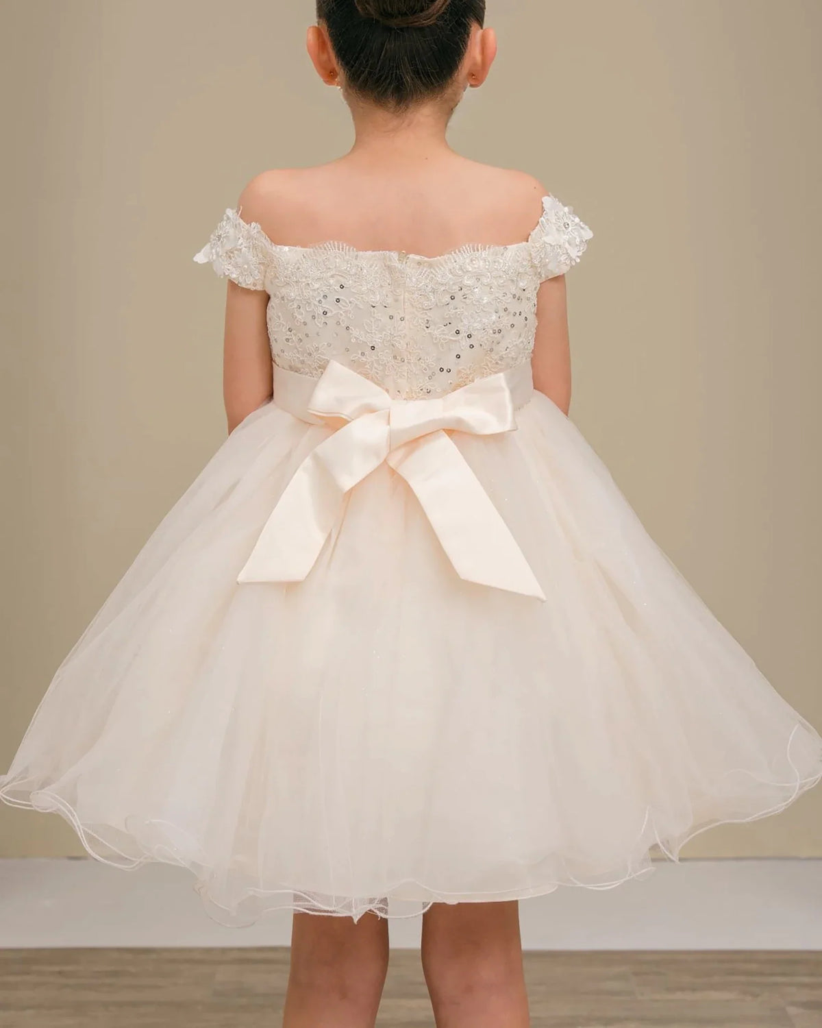 Champagne lace flower girl dress with a large bow.