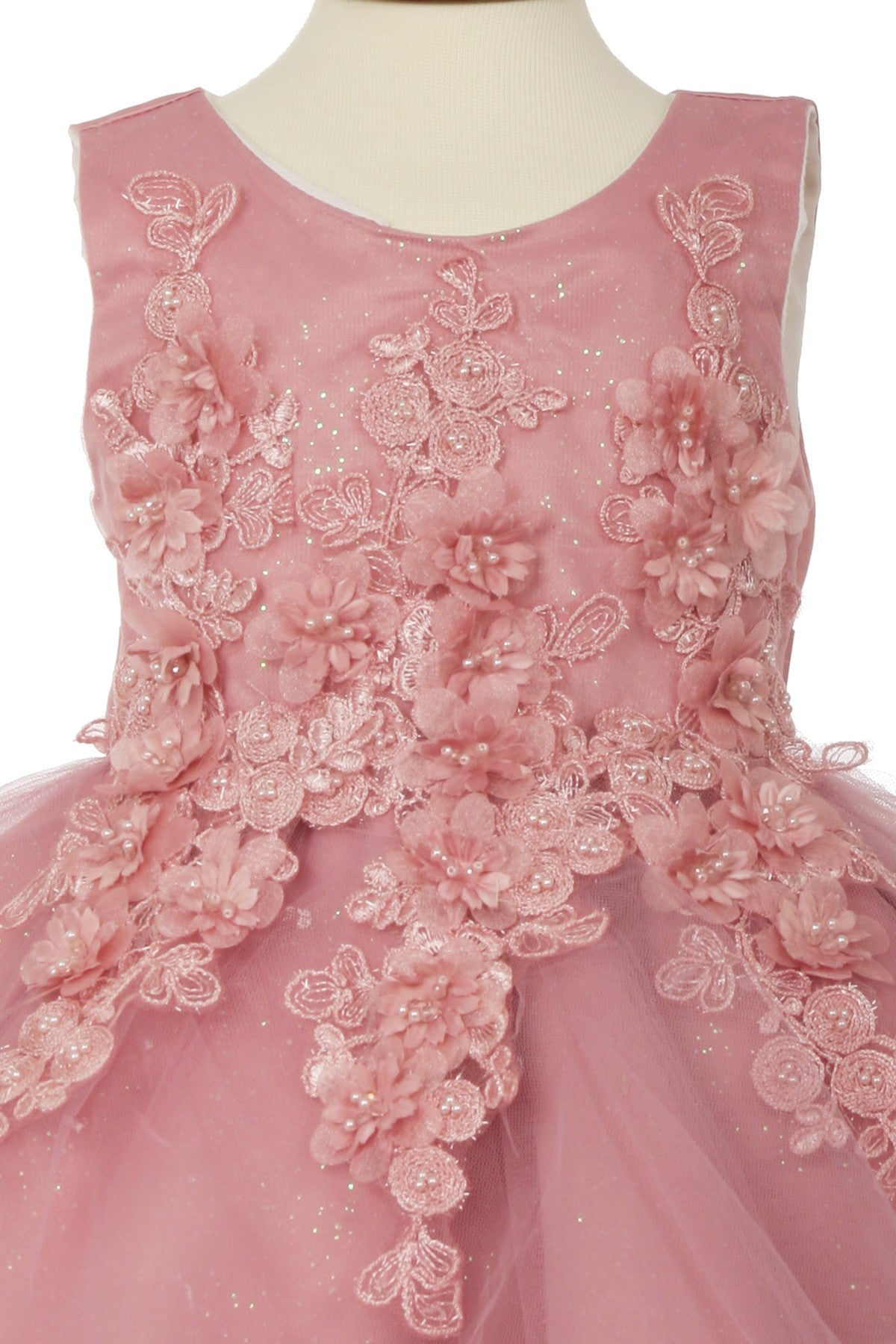 Close-up front view of rose flower girl dress showing floral applique and pearl detail.