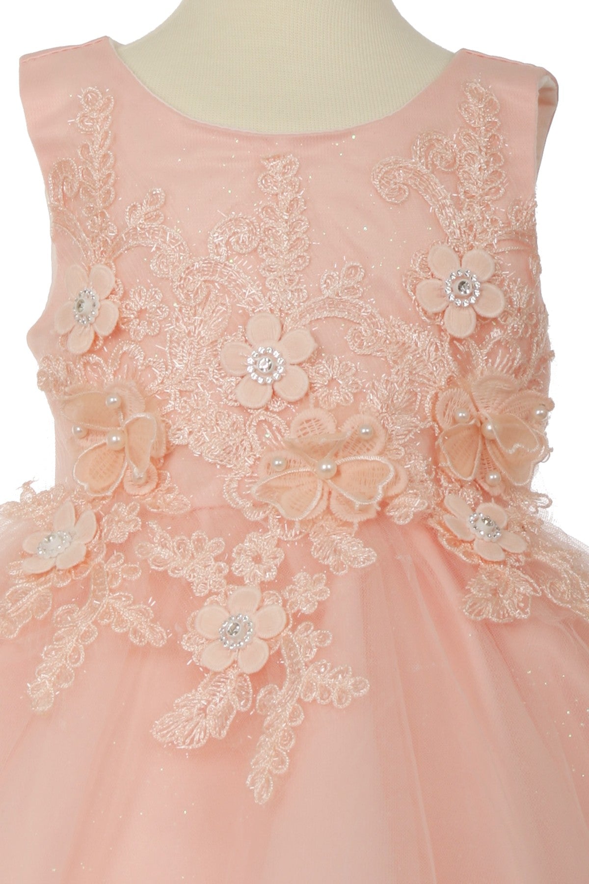 Close-up front view of blush flower girl dress showing bodice detail and soft tulle texture.