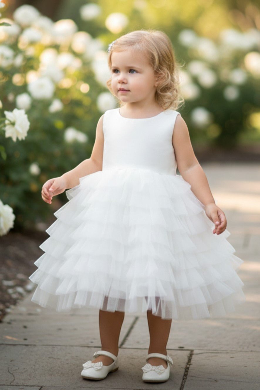 White flower girl dress front view with cap sleeves and layered tulle skirt.