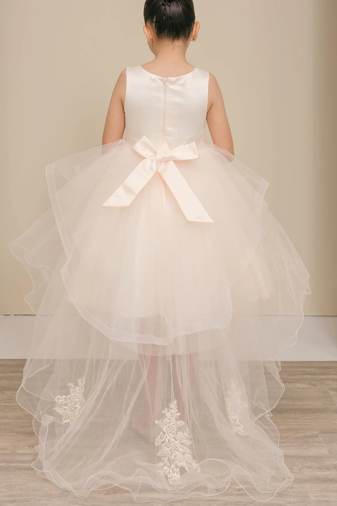 Champagne flower girl dress with a large bow.