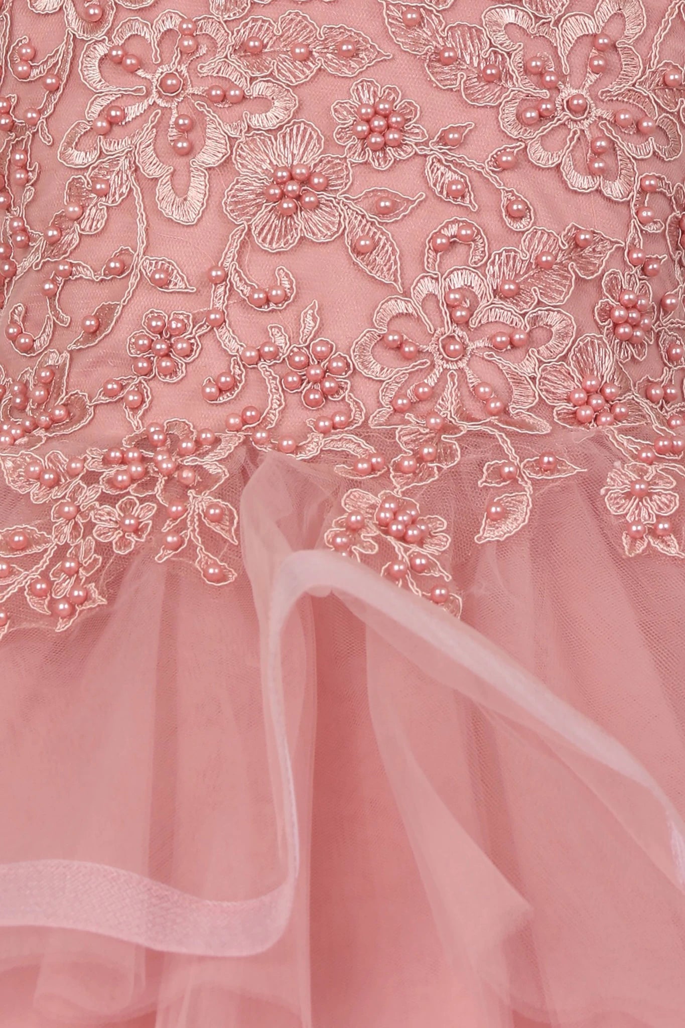 Close-up of a Dusty Rose lace fabric with floral patterns. Flower girl dress.