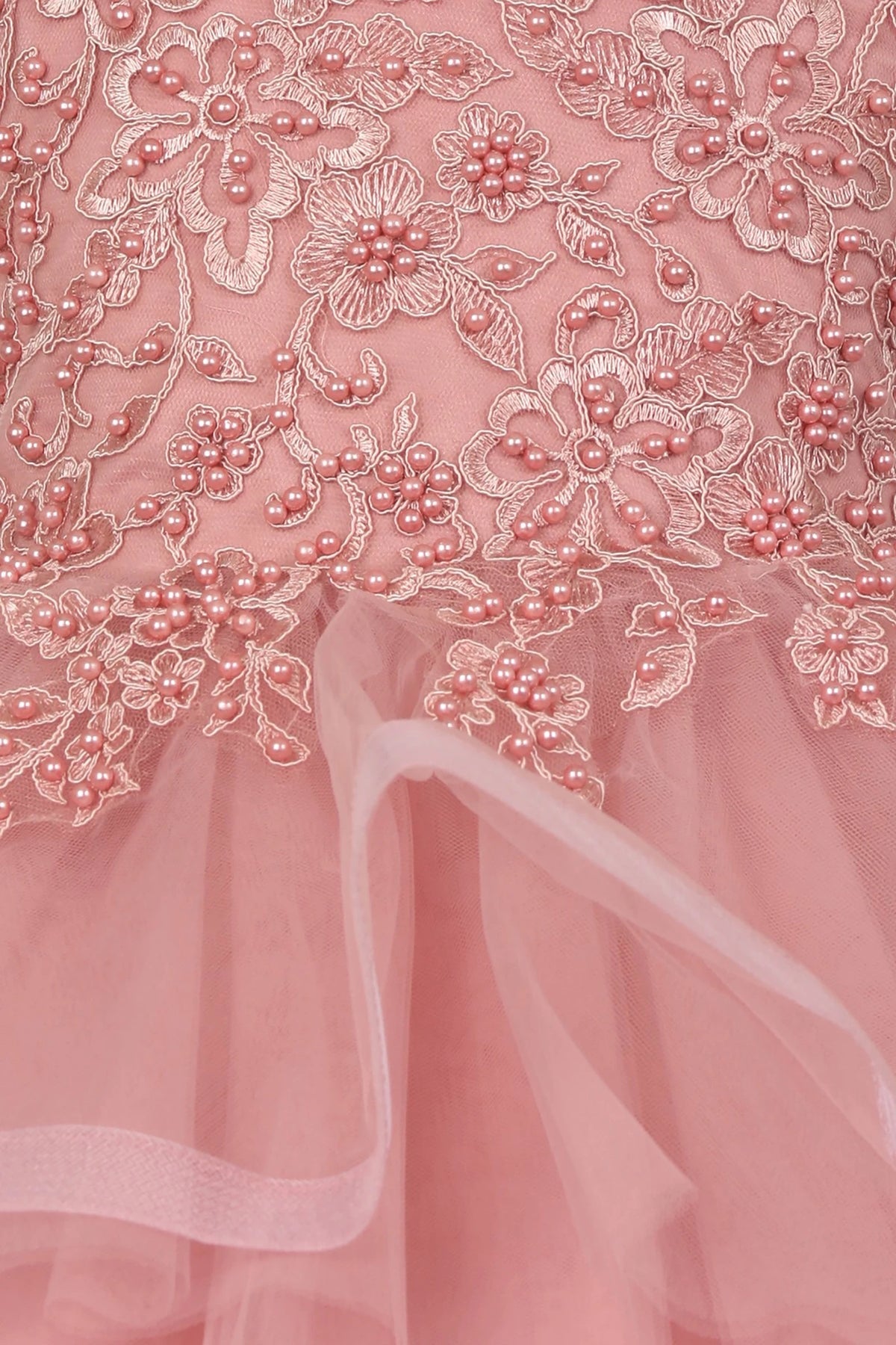 Close-up of a Dusty Rose lace fabric with floral patterns. Flower girl dress.