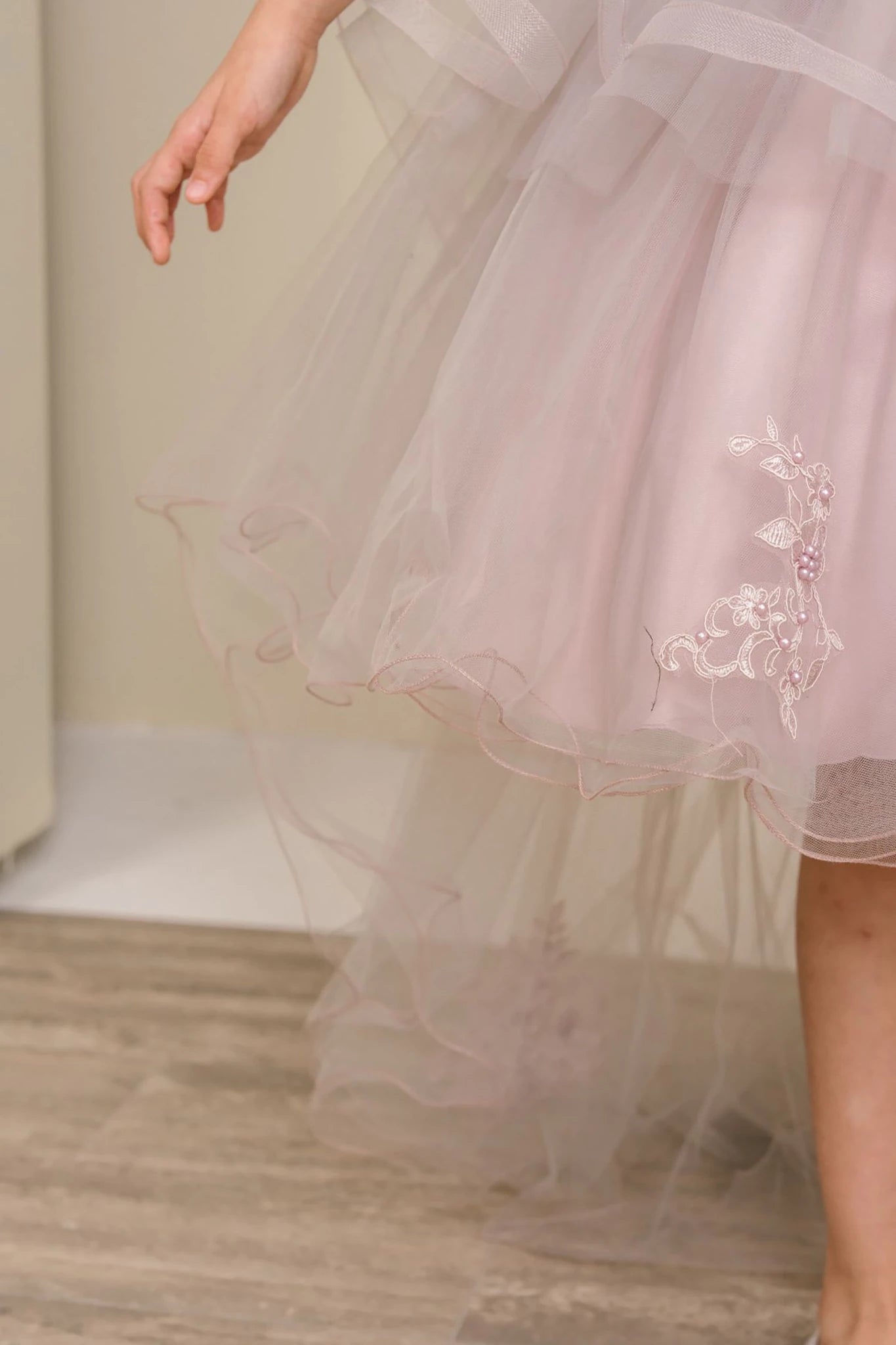 Close-up of a light Mauve flower girl dress with floral embroidery.