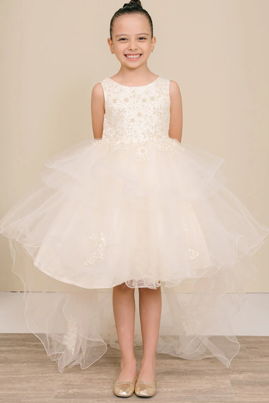 Young girl wearing a champagne floral dress against a beige background