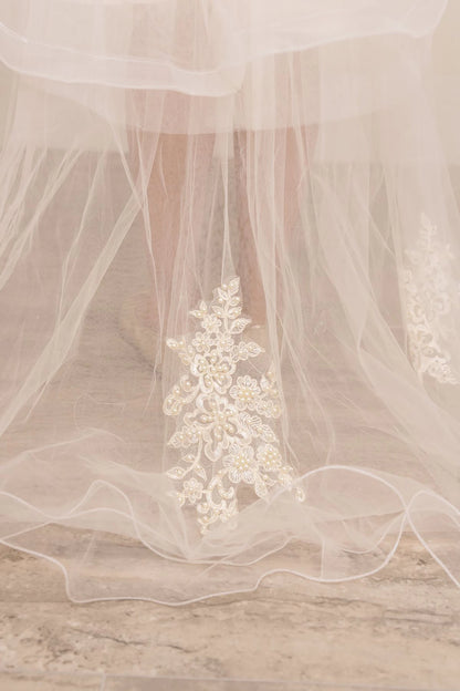 Delicate floral lace applique on a sheer fabric background