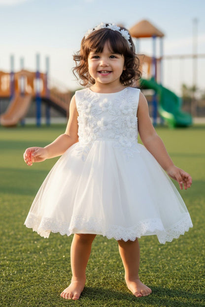 Kid Wearing White Flower Girl Dress Front View With Floral Applique Bodice And Layered Tulle Skirt