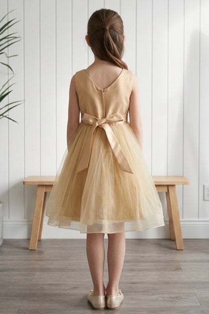 A Champagne flower girl dress showing V back and satin sash bow.