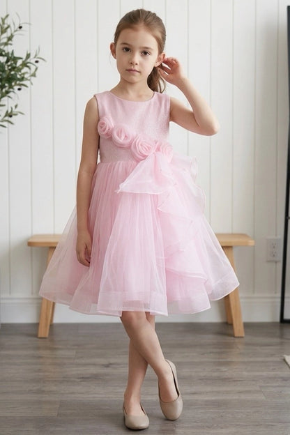 Pink flower girl dress features floral waist beside a sweeping skirt ruffle.