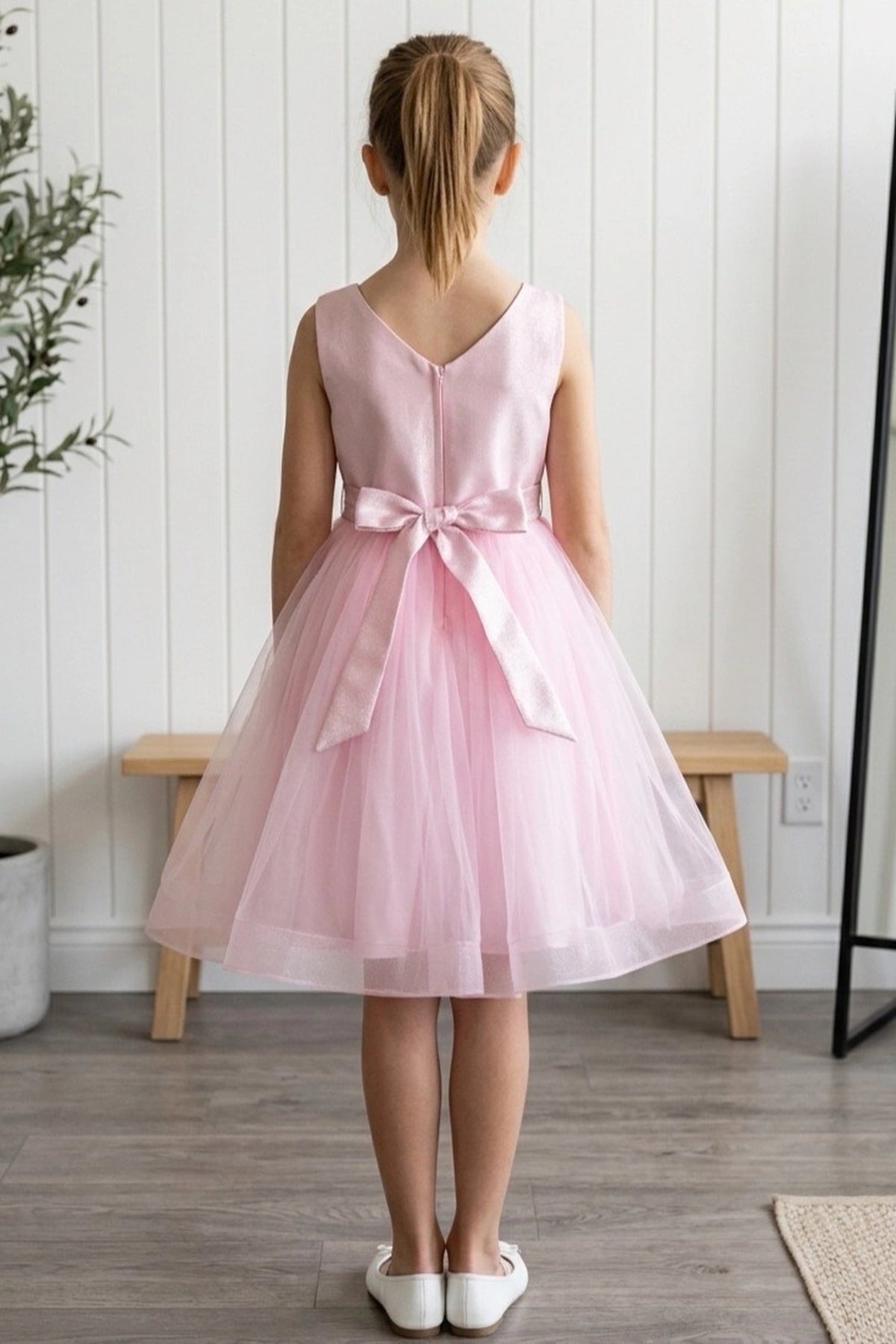 A Pink flower girl dress showing back sash bow and zipper.