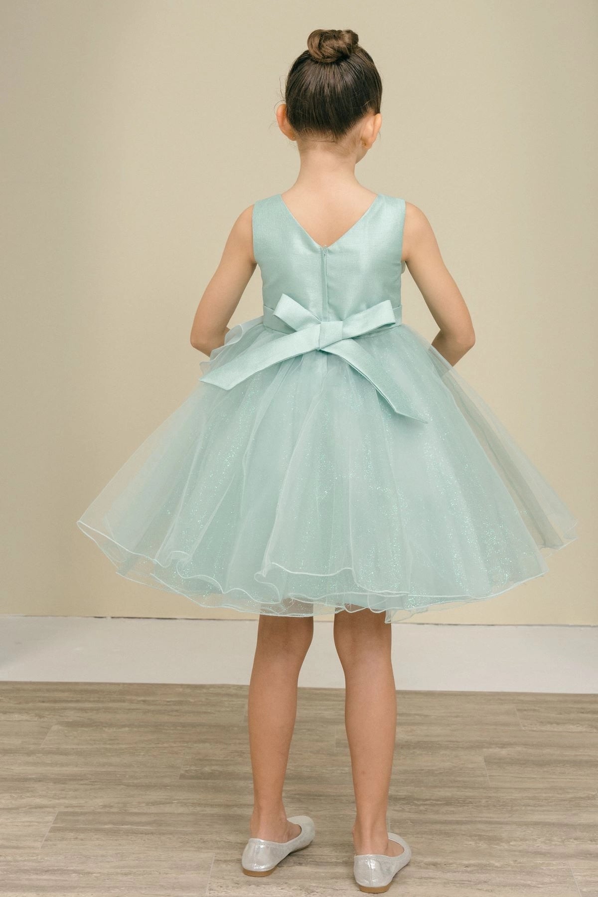A Sage flower girl dress showing V back and a tied satin sash.