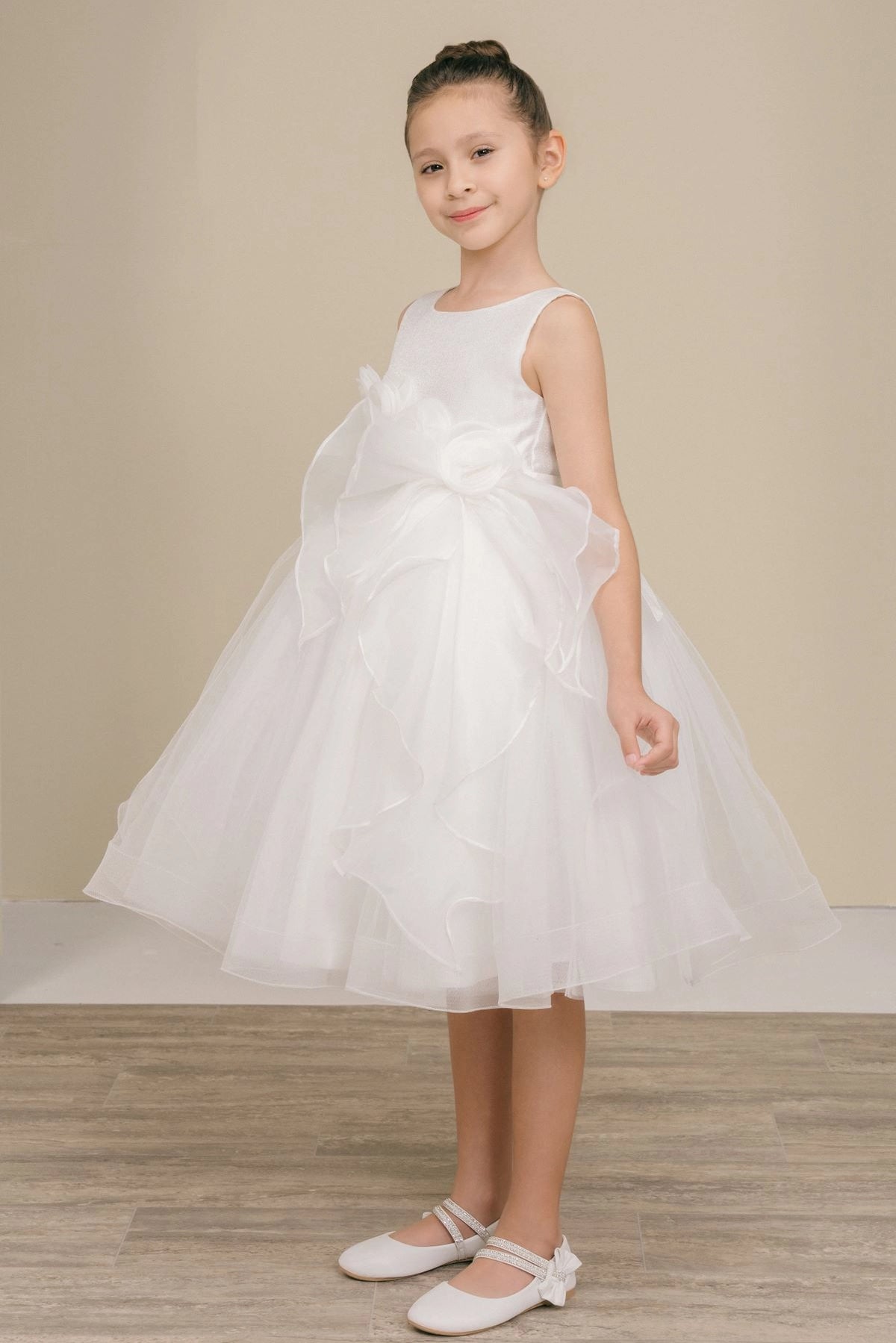 Featuring large fabric flowers and layered skirt ruffles on the White flower girl dress.
