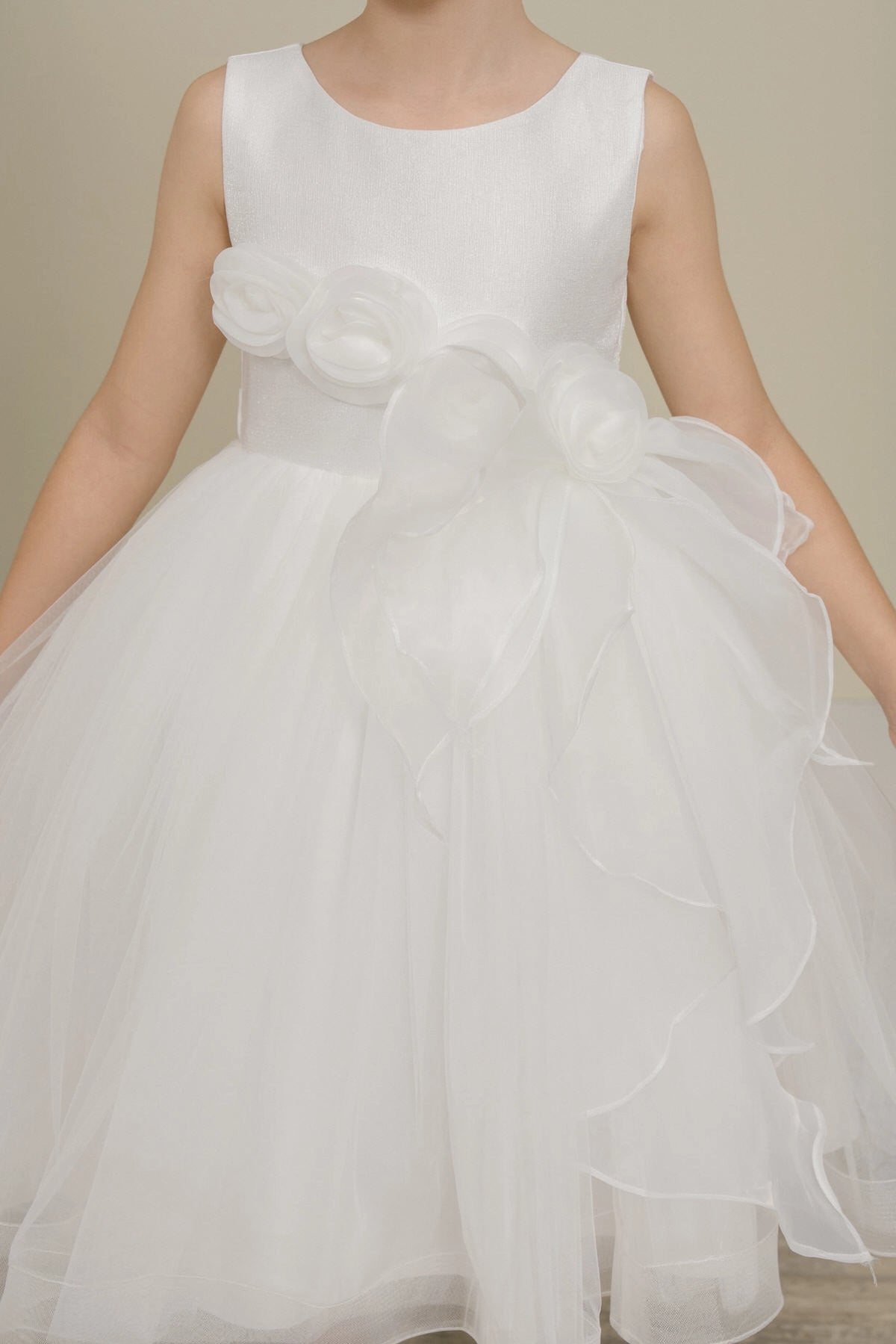 Visible on this White flower girl dress: flowers at the waist with a sweeping ruffle.
