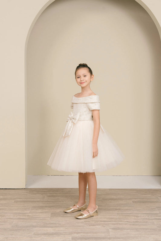 Featuring with a folded off-shoulder neckline, this Champagne kids party dress displays elegant detail.