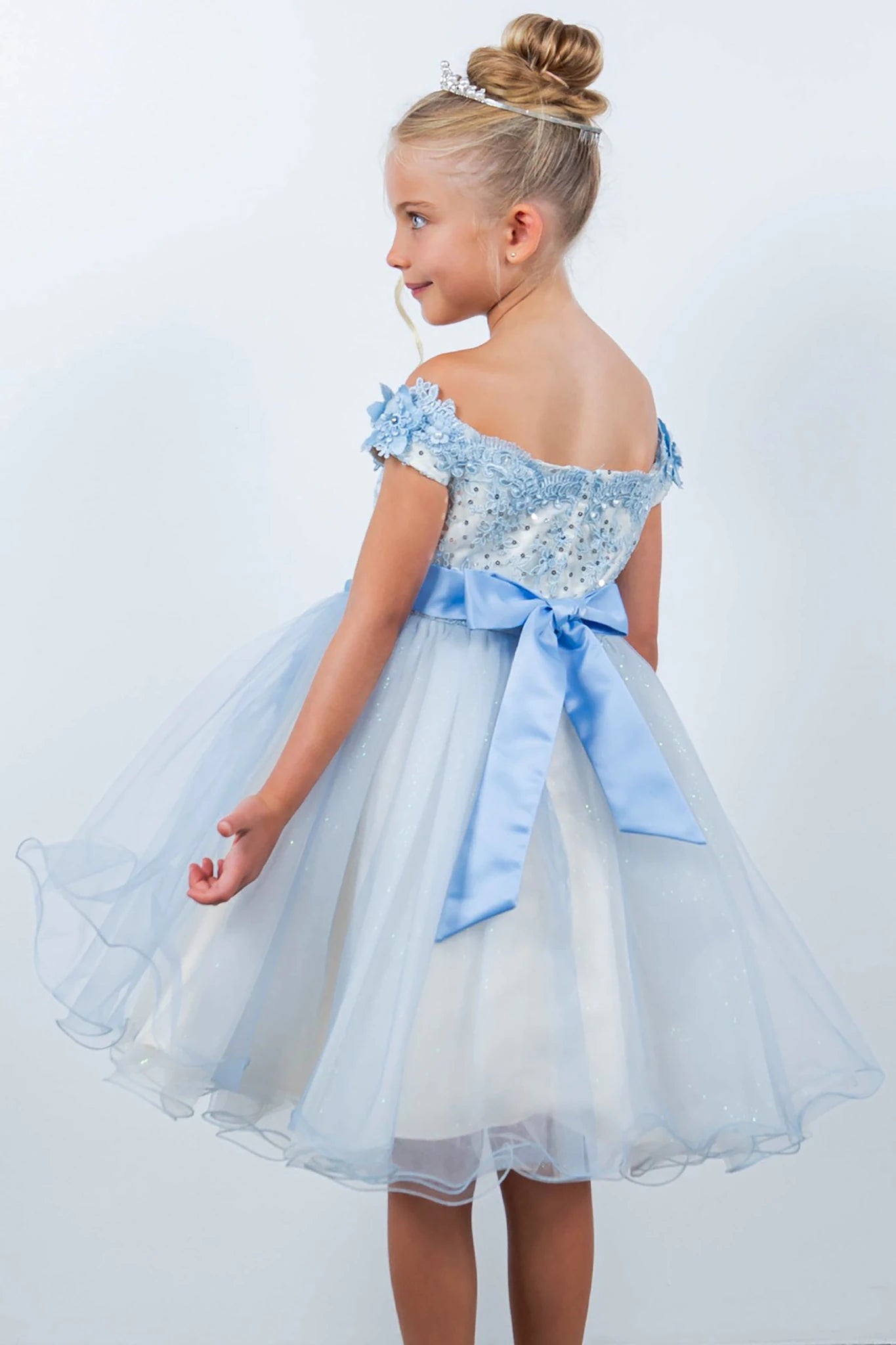 A light blue and white flower girl dress with a bow.